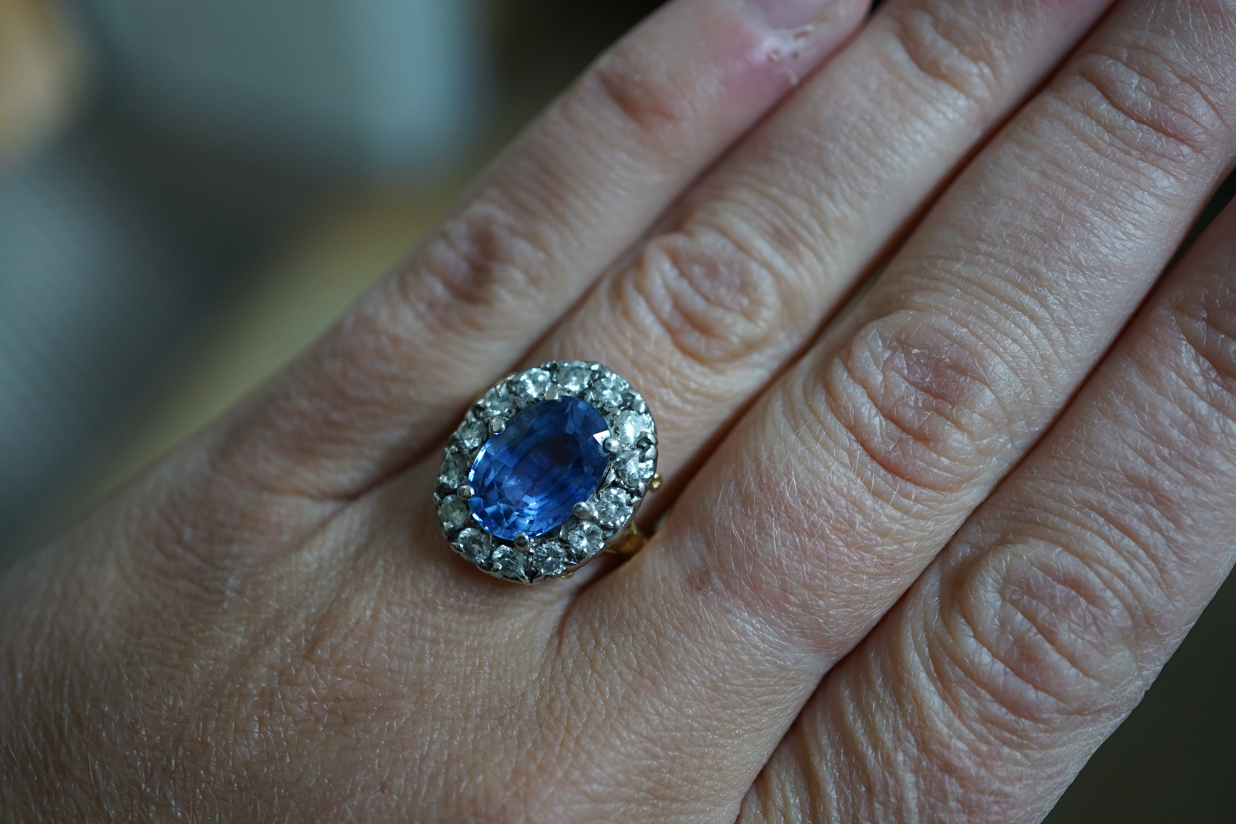 An 18ct gold, sapphire and diamond set oval cluster ring
